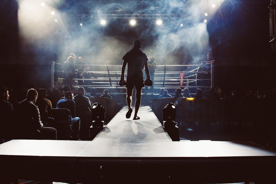 Boxare går mot en upplyst ring på en rökfylld arena